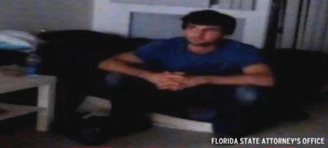 Todashev in an agent's cellphone video image, sitting on the edge of a bed by the table allegedly thrown at an FBI agent